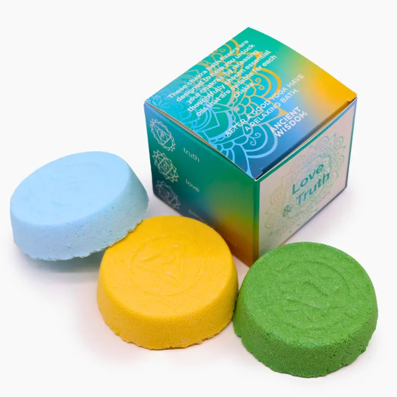 rois bombes de bain chakra (vert, bleu clair, jaune) avec motifs distincts pour chaque chakra, présentées avec un coffret "Love & Truth" au design raffiné.